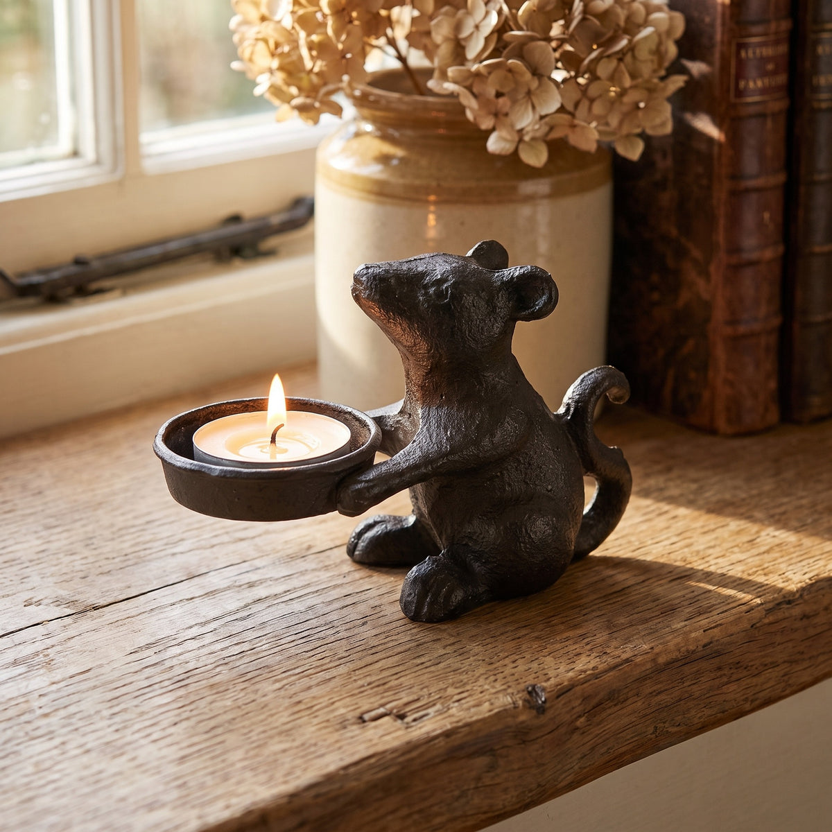 Mouse tea light holder with a lit candle in a farmhouse setting