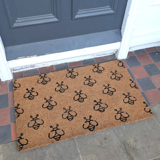 Doormat with black bee pattern in a classic coir design