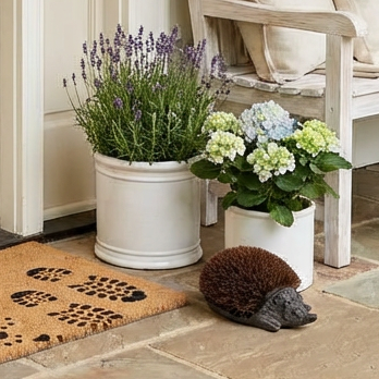 a decorative hedgehog boot brush on a stone floor.